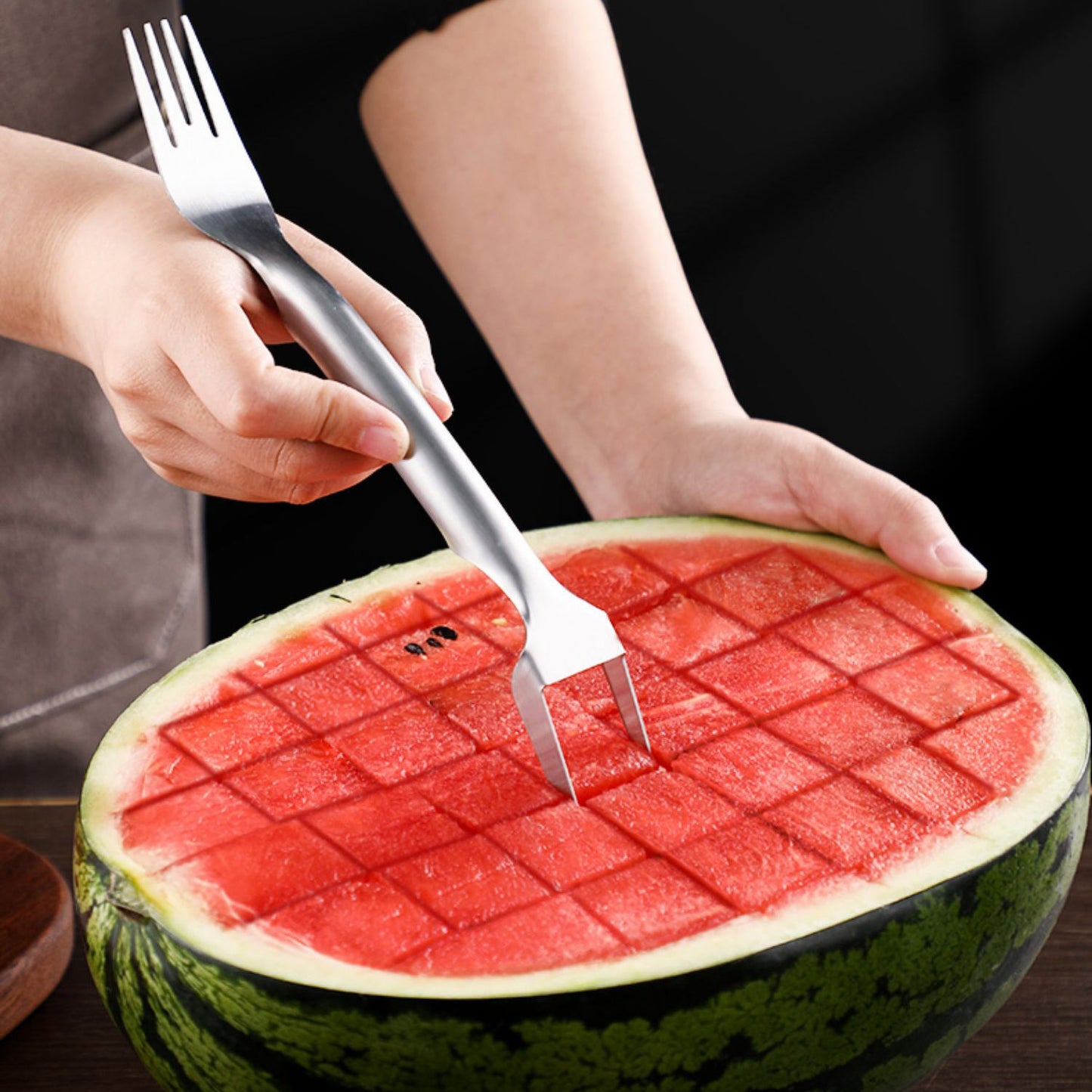 Compact slicer held in one hand over fruit